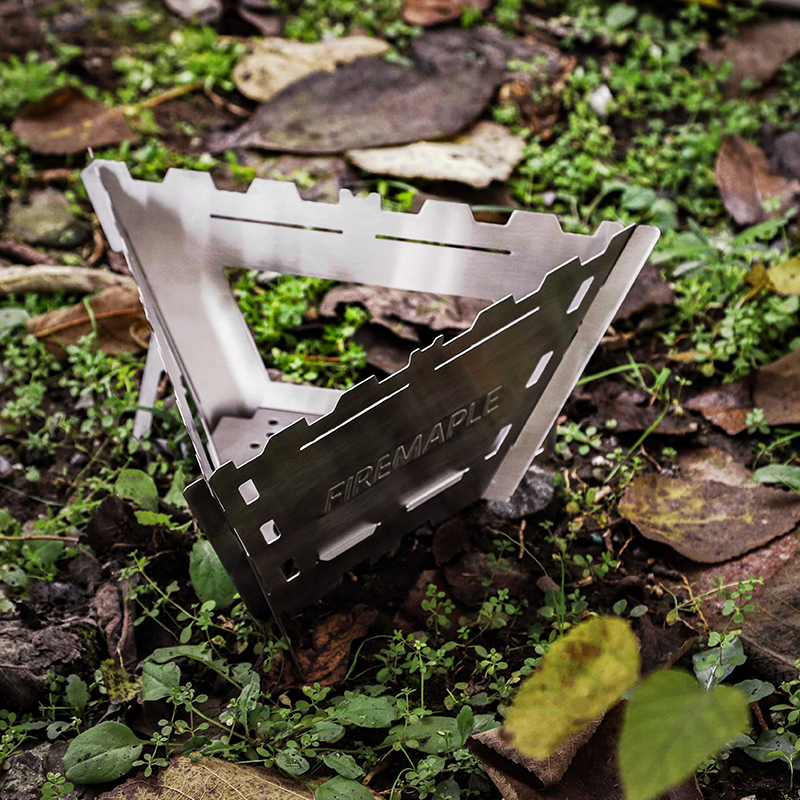 Portable stove on the ground with grass and leaves in the background #color_triangle_version