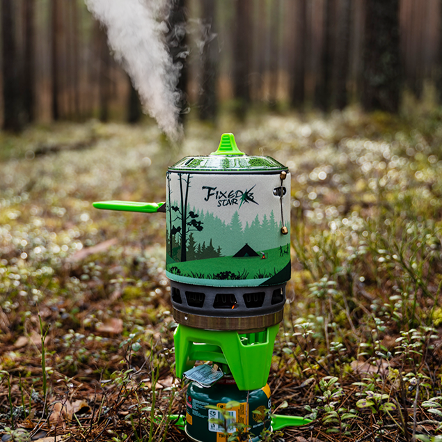 Portable stove with smoke emitting in a forest setting#color_green